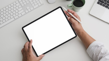 Top view of Businessman working on tablet in practical workspace with computer and laptop