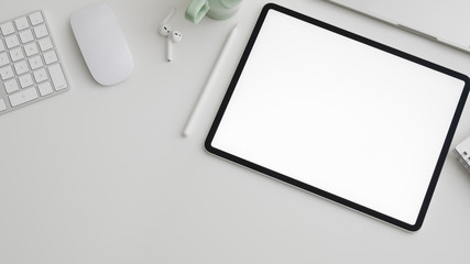 Top view of workspace with digital tablet, copy space, computer, laptop and office supplies on white desk