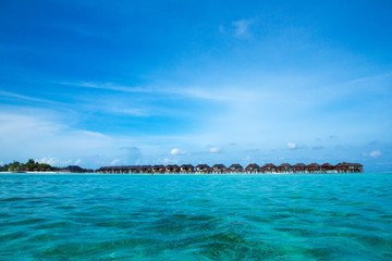Naklejka na ściany i meble Beautiful tropical Maldives island with beach. Sea with water bungalows
