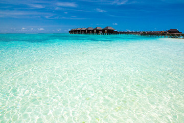 Beautiful tropical Maldives island with beach. Sea with water bungalows