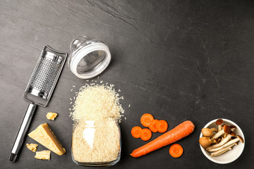 Flat lay composition with different ingredients on black table, space for text. Risotto recipe