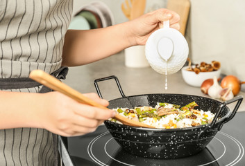Woman cooking delicious risotto, closeup. Tasty recipe