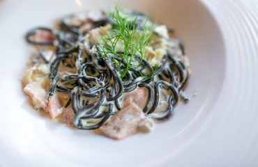 Spaghetti carbonara pasta on white dish.