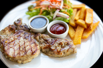 Grilled meat, Porkchops steak with pepper sauce and salad.