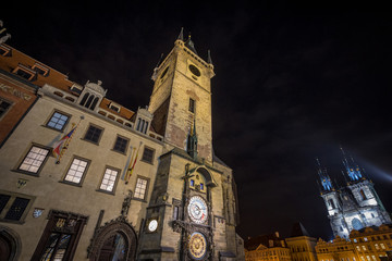 Fototapeta premium Old Town Square (Staromestske namesti) of Prague, Czech Republic, at night, with the Old Town hall in front (Staromestska Radnice) and its astronomical clock and the Cathedral in background