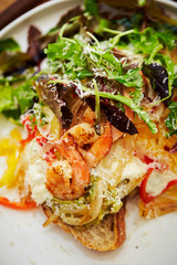 Grilled shrimp salad with tartar sauce and baguette 