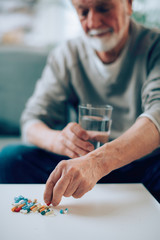 Close up of old man taking pills. Senior man drinking medicine. 