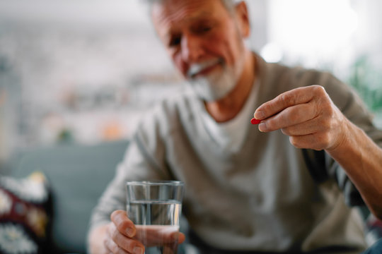 Close Up Of Old Man Taking Pills. Senior Man Drinking Medicine. 