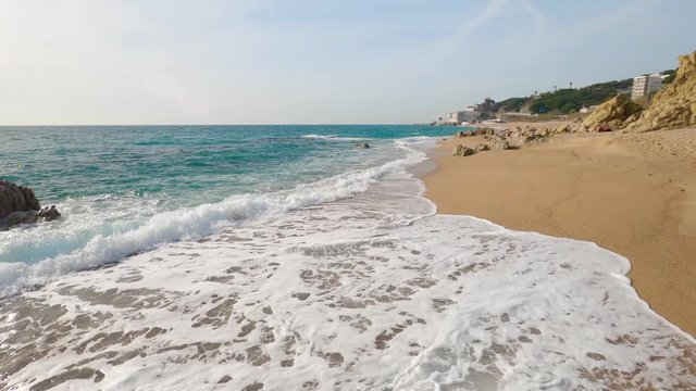 beautiful mediterranean sand beach ,maresme barcelona, san pol de mar, with rocks and calm sea and turquoise , costa brava barcelona