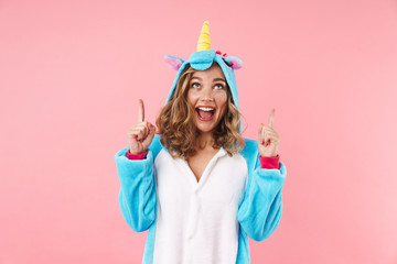 Image of caucasian excited woman pointing fingers upward