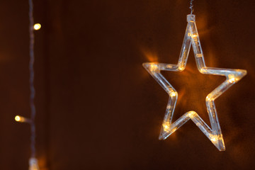 Christmas lights in the shape of a star . Yellow shiny illumination, Christmas decor, copy space. -...