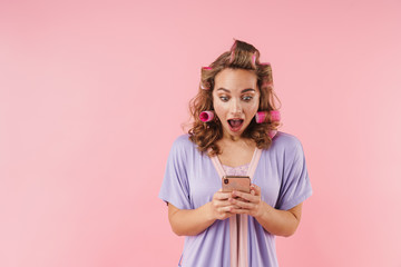 Image of young nice woman expressing surprise and using cellphone