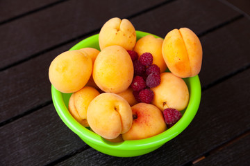 Ripe apricots in a green bowl