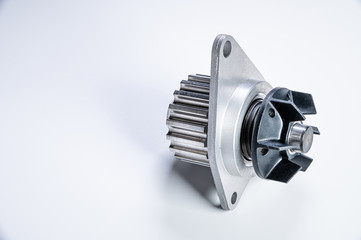 New metal automobile pump for cooling the engine of a water pump on a gray background. The concept of new spare parts for the car engine