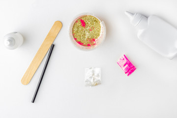 Step by step photo instruction: how to make slime at home. The concept of DIY.  Ingridients for making slime. Step 5 add glitter to the mixture of glue and dye.