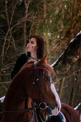 a Viking girl riding a red horse painted in black runes