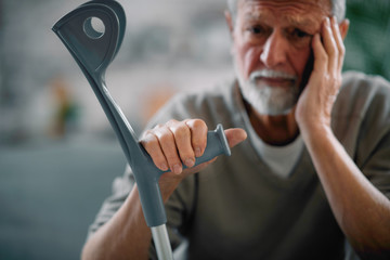 Old man with crutches. Senior man having pain.