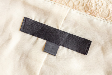 Blank black laundry care clothing label on fabric texture