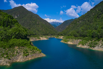 Aerial view, Lake Valvestino, Italy. Beautiful lake between the mountains. Cumulus clouds, blue sky