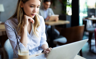 Happy young beautiful woman working, surfing, studying on laptop