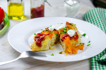 Homemade cabbage rolls with carrots, red tomato sauce and cream on a white plate