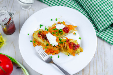 Homemade cabbage rolls with carrots, red tomato sauce and cream on a white plate