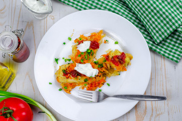 Homemade cabbage rolls with carrots, red tomato sauce and cream on a white plate