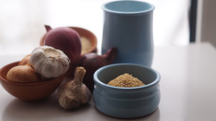 clay jugs, saucers with cereals, onions and garlic on the background of the window