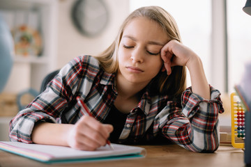 Cute little girl doesn't want to learn. Sad and tired schoolgirl.