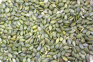 Texture green peeled pumpkin seeds background