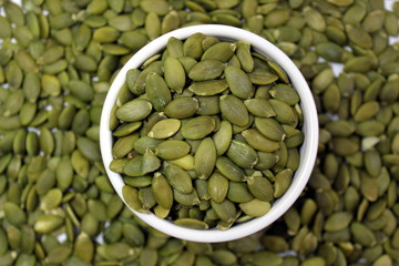 Raw peeled green pumpkin seeds in a plate
