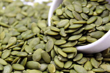 Raw peeled green pumpkin seeds in a plate
