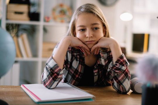 Cute little girl doesn't want to learn. Sad and tired schoolgirl.