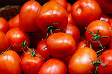 Tomates rojos maduros con tallos verdes.