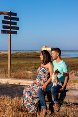 Pregnant happy couple with small dog