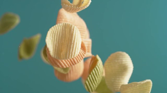 Camera follows potato chips flying in the air. Slow Motion. 