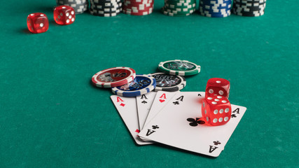 Poker chips, cards and dice on a green background. The concept of gambling and entertainment. Casino and poker