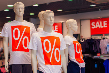 Manikens with sale sign in a shop