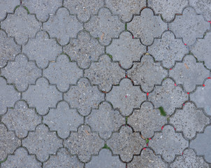 Gray road tiles of city street pavement. Cobblestone pathway paved with decorative concrete bricks.  Old gray figured pavement