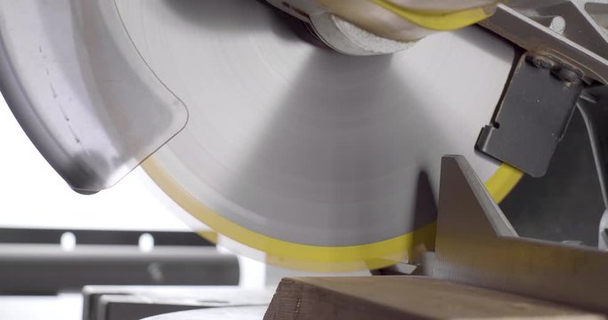 Miter Saw Cutting Wood on White Background with saw dust