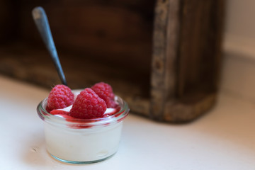 close up. glass bowl with yogurt and raspberry 
