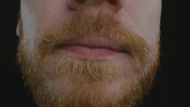 Macro shot of bearded man taking pill isolated.