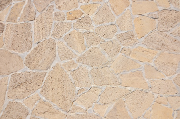 Old beige stone wall background texture close up. Old castle stone wall texture