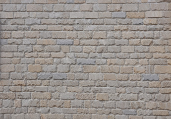 An example of ancient masonry as a cladding of external walls of castle. Natural stone background.  Beige stone wall texture with torn edges