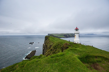 Fototapeta na wymiar Mykines lighthouse, Faroe Islands. Foggy view of old lighthouse