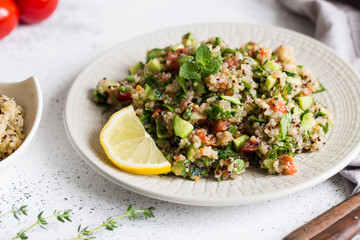 Quinoa salad with fresh tomatoes, cucumbers and salad leaves. Superfood and healthy eating concept.