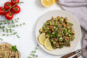 Quinoa salad with fresh tomatoes, cucumbers and salad leaves. Superfood and healthy eating concept.
