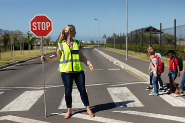 Woman wearing a high visibility vest and holding a stop sign