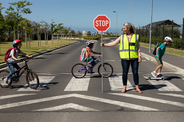 Woman wearing a high visibility vest and holding a stop sign