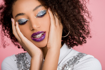 tender african american woman with silver glitter eyeshadows and purple lips wearing paillettes...